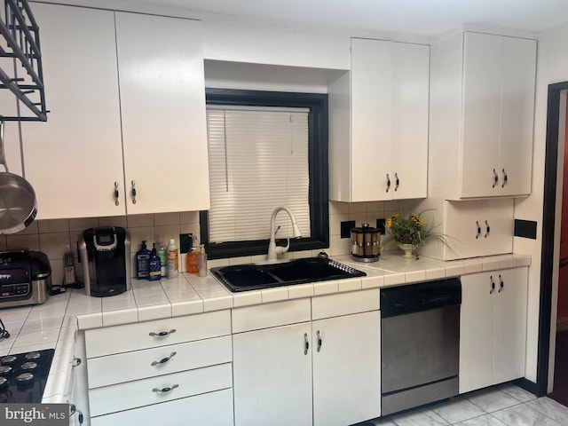 kitchen with dishwasher, white cabinetry, sink, and tile counters