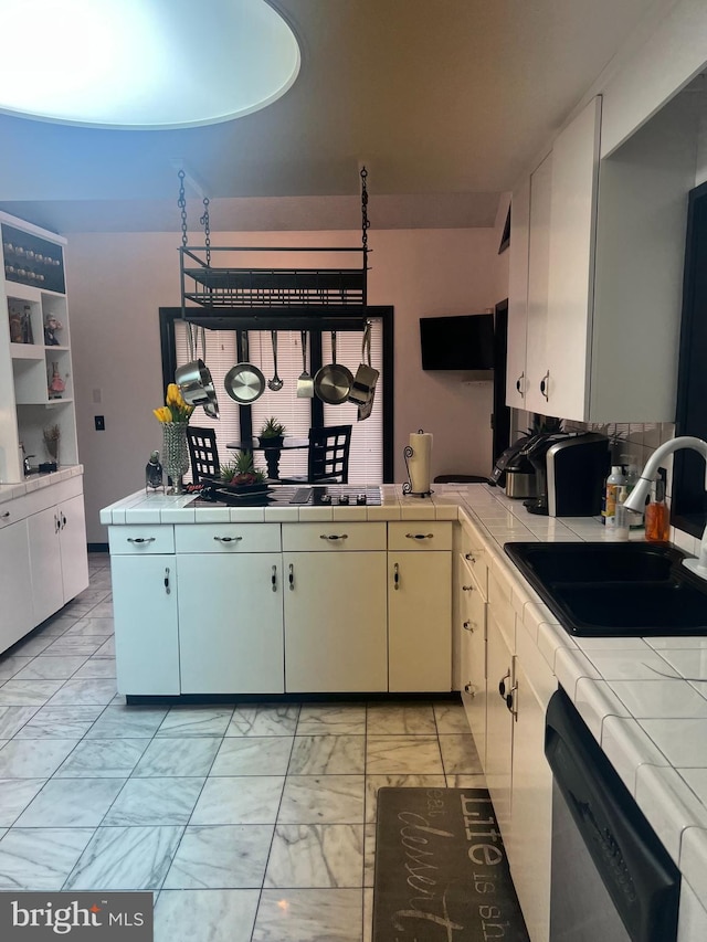 kitchen featuring white cabinets, tile counters, sink, and dishwasher