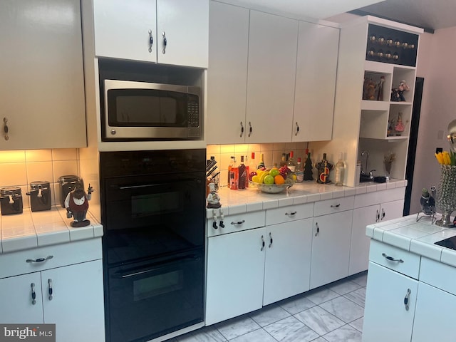 kitchen featuring tile counters and white cabinetry