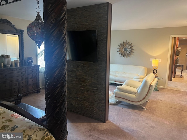 bedroom with a stone fireplace and carpet