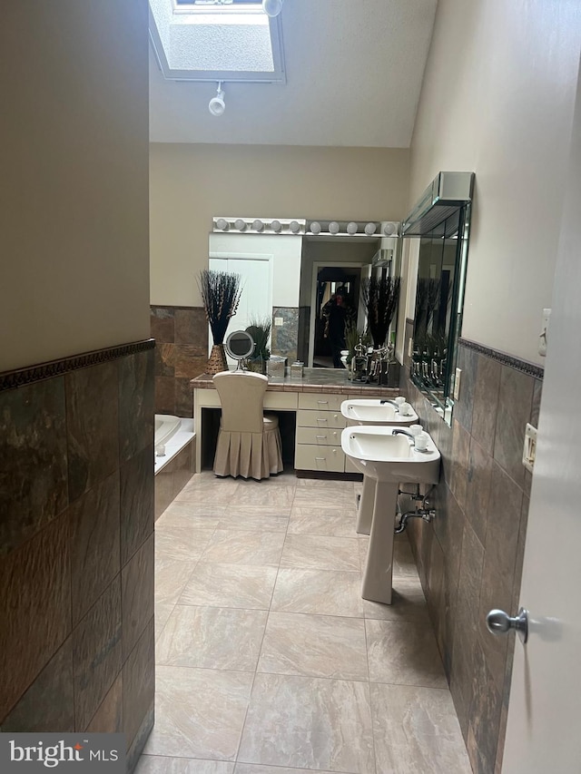 bathroom featuring tile walls, tile patterned floors, a tub, and vaulted ceiling with skylight