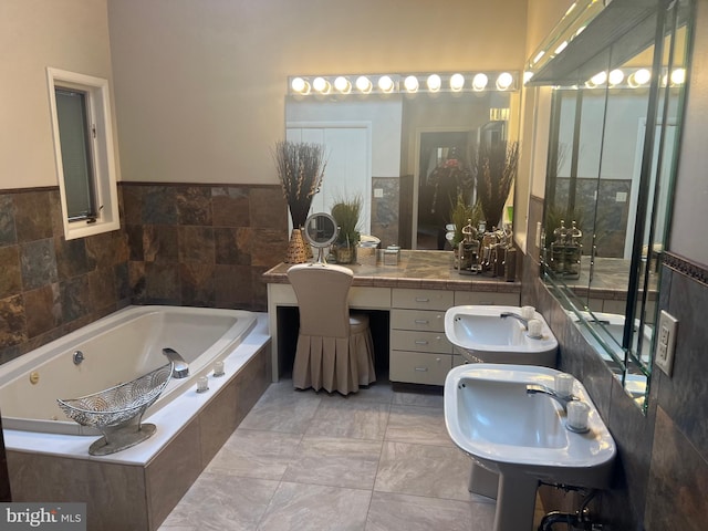 bathroom with tile walls, vanity, and a relaxing tiled tub