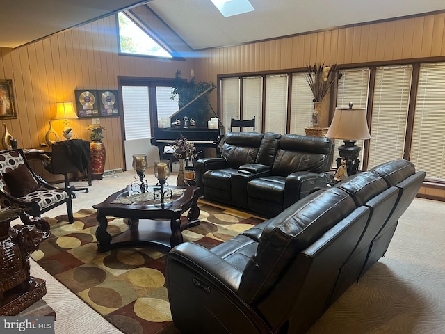 living room with carpet, wooden walls, and lofted ceiling with skylight