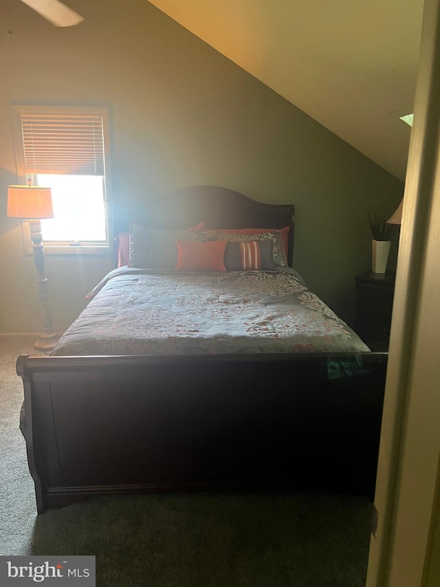 bedroom featuring ceiling fan, vaulted ceiling, and carpet