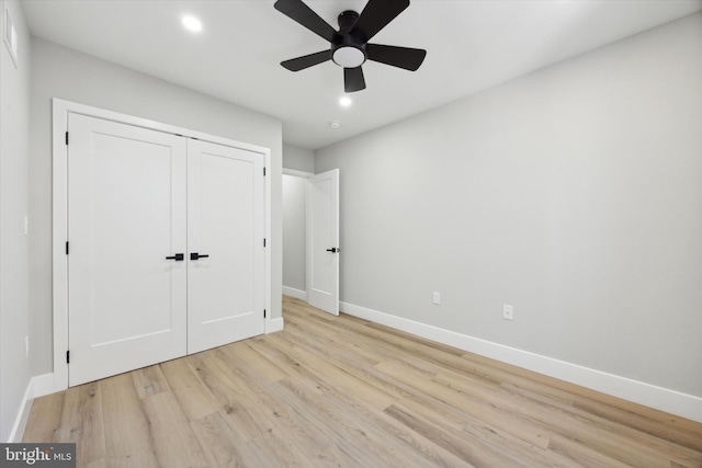 unfurnished bedroom with light hardwood / wood-style floors, ceiling fan, and a closet