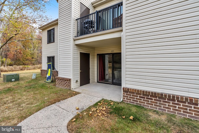 doorway to property with a yard and a balcony