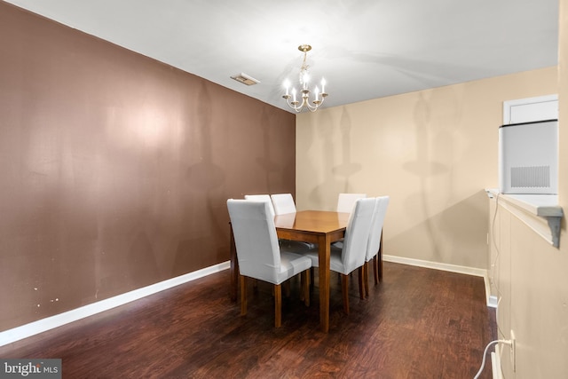 dining area with dark hardwood / wood-style floors and a notable chandelier