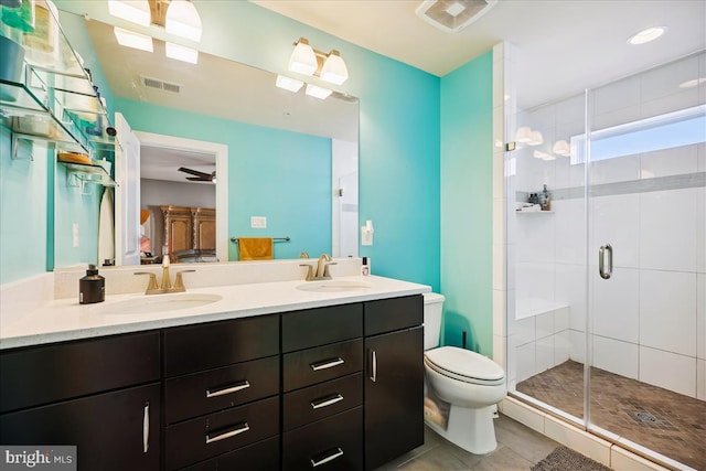 bathroom with vanity, ceiling fan, tile patterned flooring, toilet, and a shower with shower door