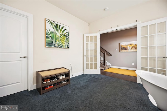 miscellaneous room featuring dark colored carpet and french doors