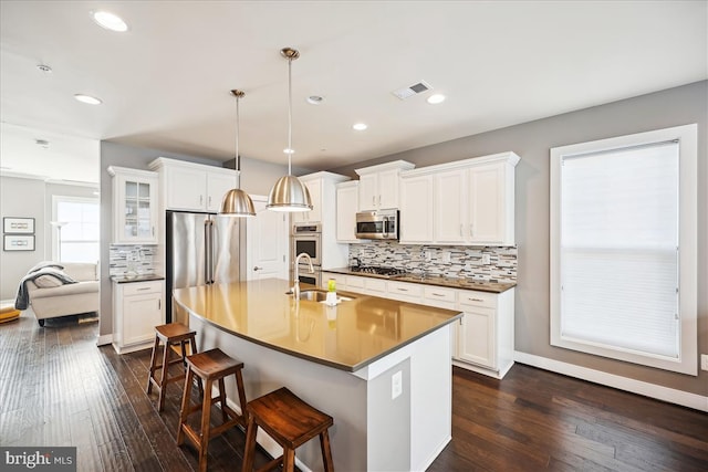 kitchen with dark wood-type flooring, hanging light fixtures, white cabinets, and stainless steel appliances