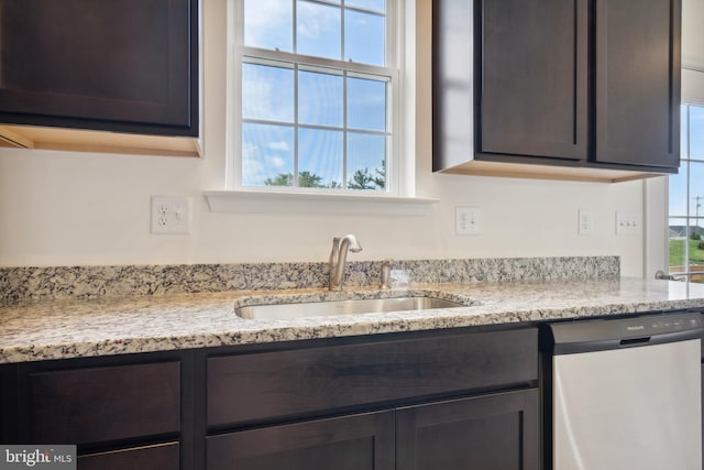 room details with dark brown cabinetry, light stone countertops, sink, and dishwasher