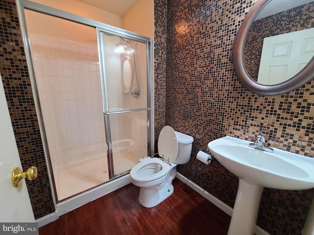 bathroom featuring toilet, tile walls, hardwood / wood-style floors, tasteful backsplash, and an enclosed shower