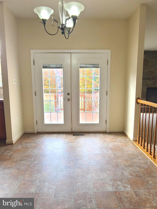 doorway to outside with an inviting chandelier and french doors