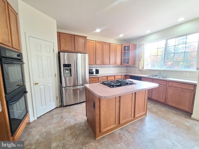 kitchen featuring black appliances, sink, and a center island