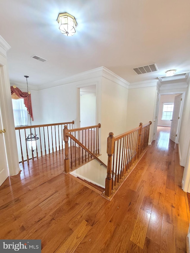 hall with ornamental molding and light hardwood / wood-style flooring