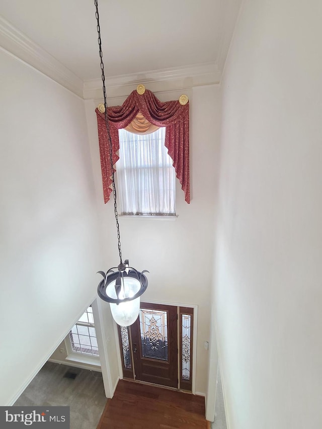 entrance foyer featuring a notable chandelier, dark hardwood / wood-style floors, and crown molding