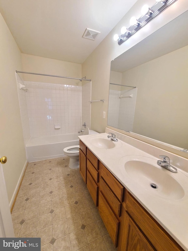 full bathroom with toilet, tiled shower / bath combo, vanity, and tile patterned flooring