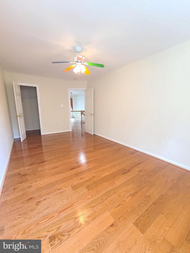 unfurnished room with light wood-type flooring and ceiling fan