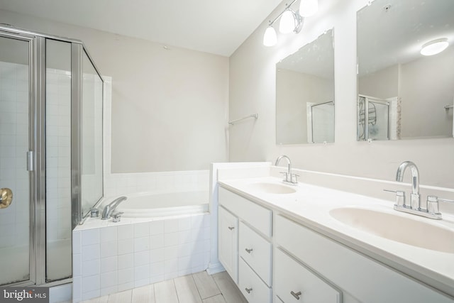 bathroom featuring shower with separate bathtub and vanity