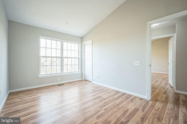 unfurnished room with light hardwood / wood-style flooring and vaulted ceiling