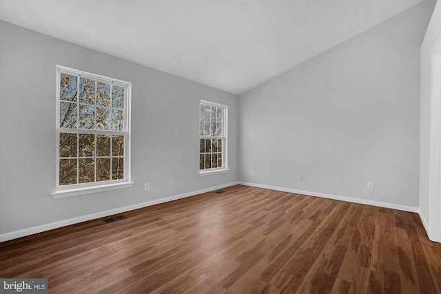 empty room with hardwood / wood-style flooring and lofted ceiling