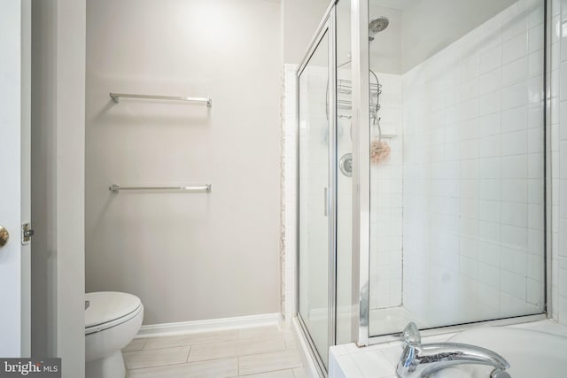 bathroom featuring toilet and a shower with shower door