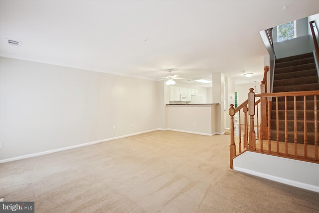 unfurnished living room with ceiling fan and light colored carpet