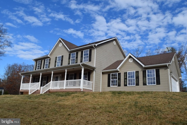 colonial home featuring a front lawn, a garage, and a porch