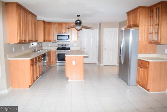 kitchen featuring appliances with stainless steel finishes, ceiling fan, a kitchen island, and light tile patterned flooring