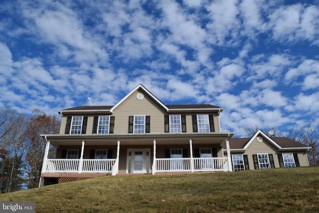 colonial home featuring a front yard and a porch