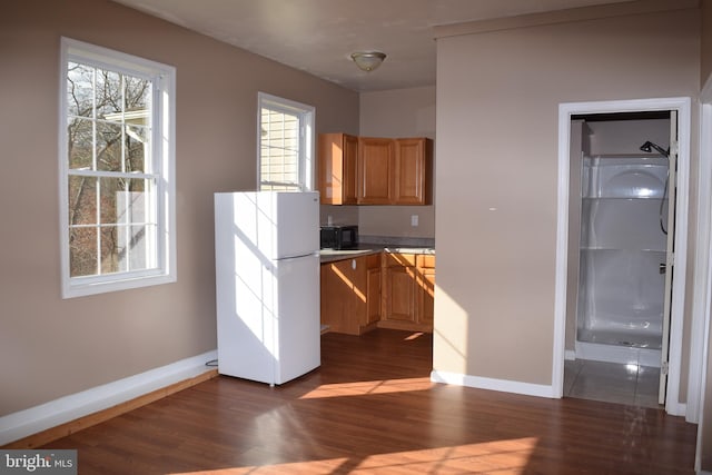 531 Washout Ln, Winchester, VA 22603 - kitchen featuring freestanding refrigerator, black microwave, dark wood-style floors, light brown cabinets, and baseboards