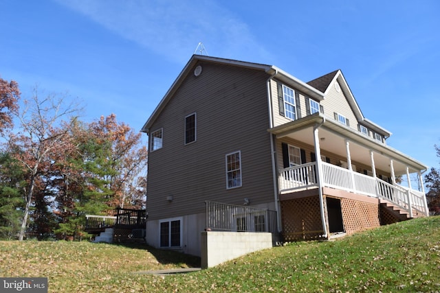 view of property exterior with a lawn and a deck