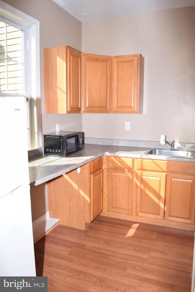 531 Washout Ln, Winchester, VA 22603 - kitchen with freestanding refrigerator, light brown cabinetry, a sink, black microwave, and light wood-type flooring