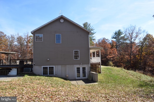 back of property with a lawn and a wooden deck