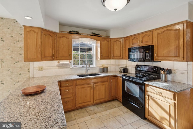 kitchen with backsplash, light stone counters, sink, black appliances, and light tile patterned floors