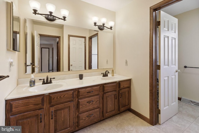 bathroom featuring tile patterned floors, a notable chandelier, and vanity