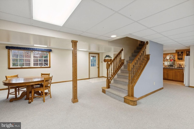 basement with light carpet and a paneled ceiling