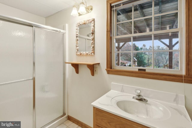 bathroom featuring a shower with door and vanity