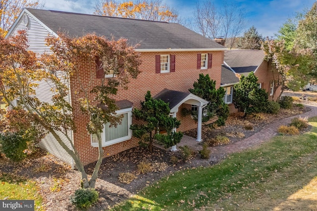 view of front of house featuring brick siding and a shingled roof