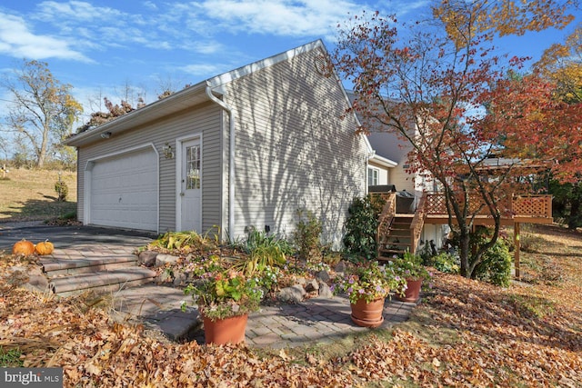 view of side of home with a garage and a deck