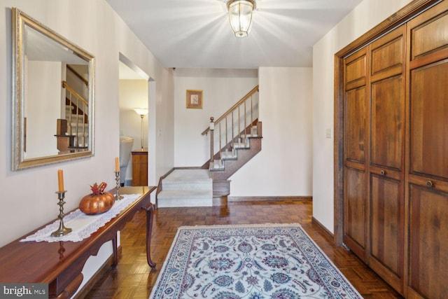 foyer entrance featuring dark parquet flooring