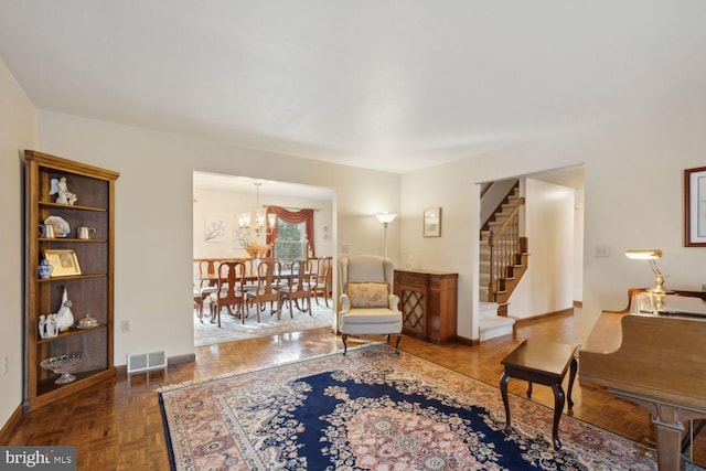 sitting room with dark parquet flooring and an inviting chandelier