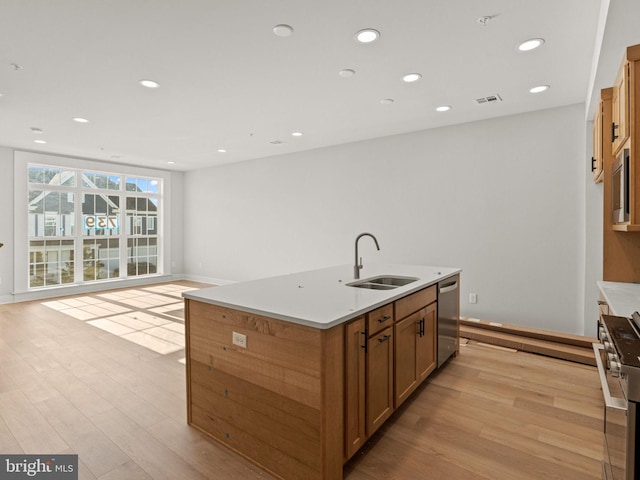 kitchen featuring a center island with sink, stainless steel appliances, light hardwood / wood-style floors, and sink