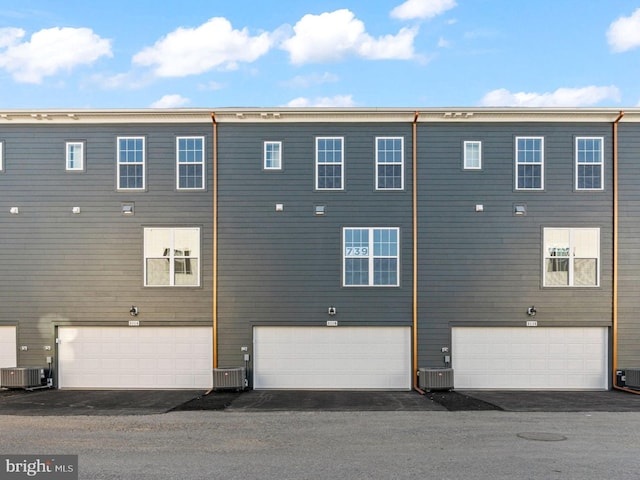 back of property featuring central AC and a garage