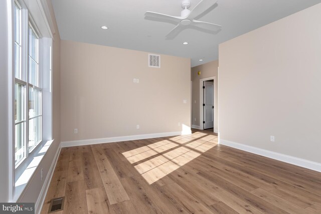 unfurnished room with ceiling fan, a healthy amount of sunlight, and light wood-type flooring