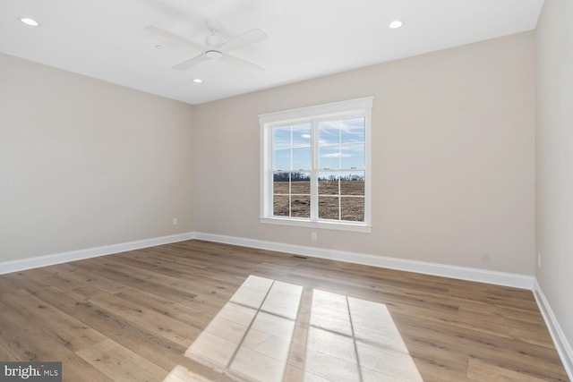 spare room featuring light hardwood / wood-style flooring and ceiling fan