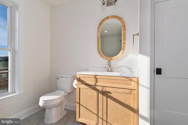 bathroom featuring tile patterned flooring, vanity, and toilet