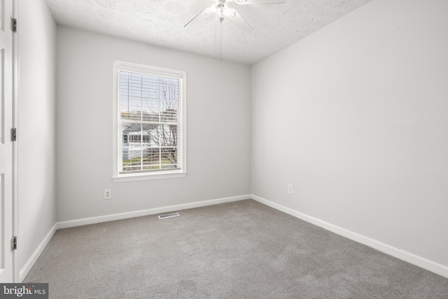 carpeted spare room with ceiling fan and a textured ceiling