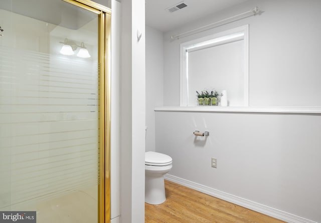 bathroom featuring toilet, wood-type flooring, and walk in shower