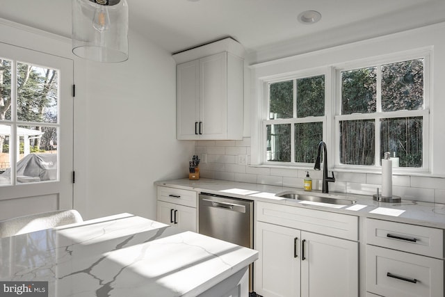 kitchen featuring white cabinets, sink, light stone counters, and tasteful backsplash